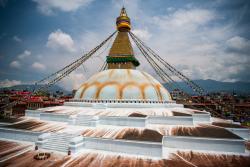 Stupa Budhanath s bielou kupolou a zlatým vrchom s vlajkami a očami. Nepál
