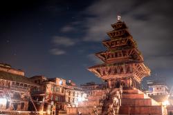 Vysvietené večerné námestie v Bhaktapur s drevenými chrámami a domami v Nepále. 