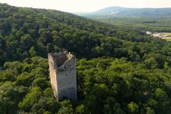 Zelené kopce Burngenlandu s hradnou vežou. Rakúsko