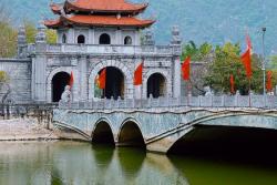 Histroická brána červená strecha, most a rieka. Vietnam. Foto: unsplash.com