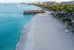 Tyrkysové more, biela piesková pláž, palmy a hotely. Aruba. Foto: unsplash.com