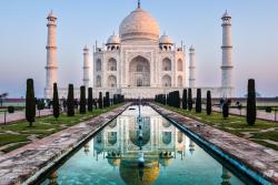Biela mramorová stavba s kupolami, vežami, záhradou a bazénom. Tádž Mahal, India