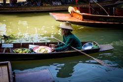 Thajka plaviaca sa po kanáli a predávajúca z lode svoj tovar. Thajsko