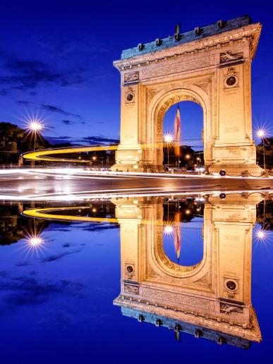 Víťazný oblúk v Bukurešti s odrazom po západe slnka.