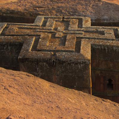 Kamenný kostol s krížom v zemi.