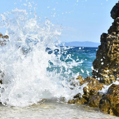 Pláž, vlny a sklay pri meste Rabac.