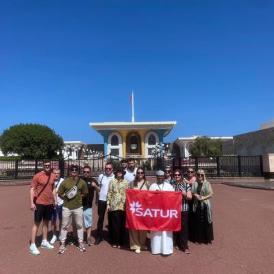 Skupina pri paláci v Muscate s vlajkou SATUR.