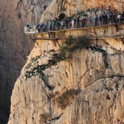 Turisti prechádzajú chodníkom na skalnom masíve, Caminito del Rey.