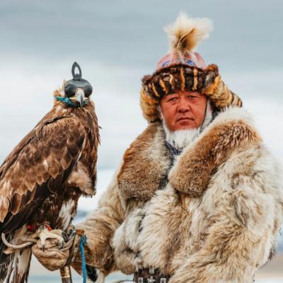 Muž v kožuchu s orlom v Mongolsku.