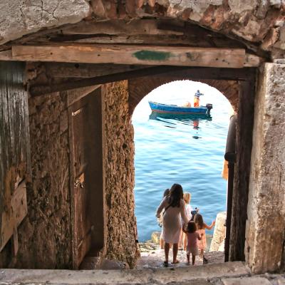 Kamenné schody, ľudia a brána ku moru v meste Rovinj