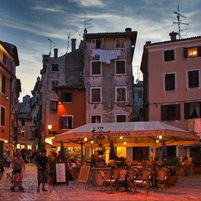 Večerné mesto Rovinj a ľudia v ulici.