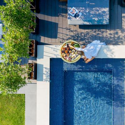 Žena v bielom pri bazéne s raňajkami v hoteli v Dubaji.