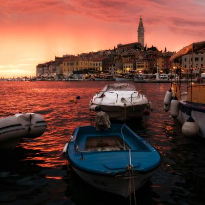 Západ slnka v meste Rovinj a lode v prístave.