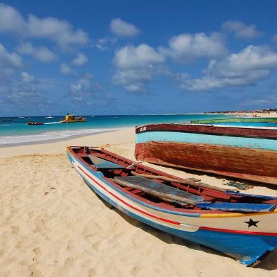Piesková pláž, more a drevené farebné loďky. Kapverdy.