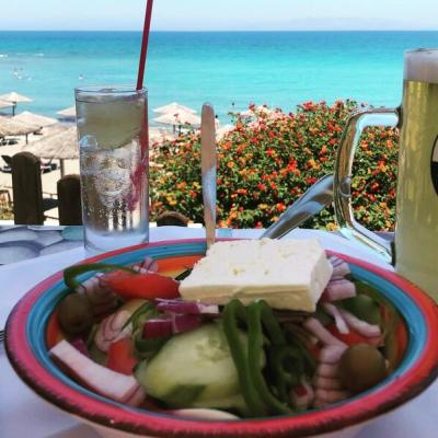 Grécky šalát, pivo a výhľad na more z reštaurácie.