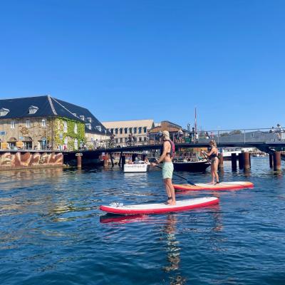 Dvaja ľudia na paddleboarding v Kodani.