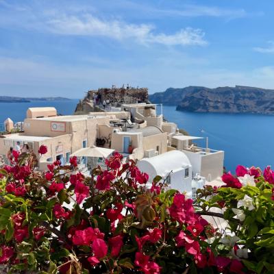 Západ slnka v Oia, kvety a biele domy. Santorini.