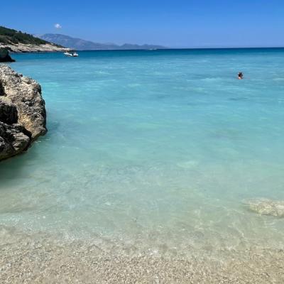 Zátoka Xigia s blankytnou farbou mora a kúpajúca sa žena.