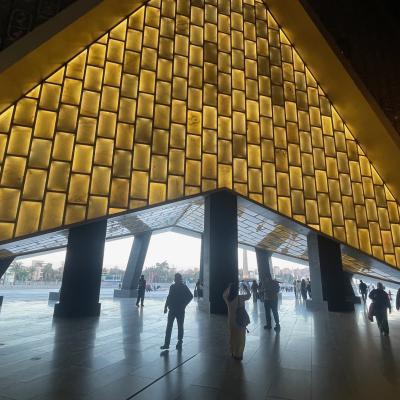 Vchod do nového múzea v podobe pyramídy a návštevníci.