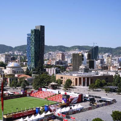 Štadión a moderné budovy v Tirane.
