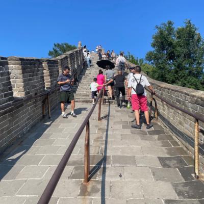 Strmé kamenné schody na Veľkom čínskom múre a turisti.