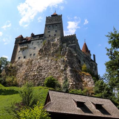 Hrad Bran na brale a drevený dom.