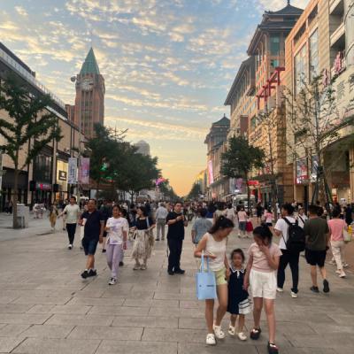 Nákupná ulica Wangfujing v Pekingu a kráčajúci ľudia.