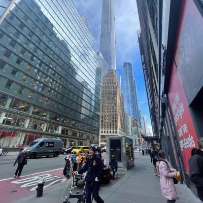 Mrakodrapy New Yorku počas dňa a chodci.