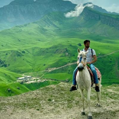 Zelené pohorie a muž na koni v Azerbajdžane.