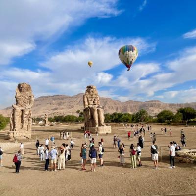 Lietajúce balóny nad sochami a návštevníci v Egypte.