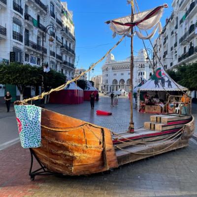 Drevená loď a budovy v Alžíri.