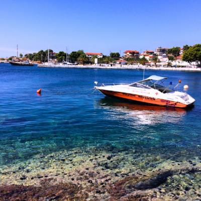 Grécky prístav, loď a tyrkysové more na Chalkidiki.