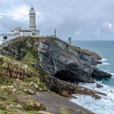 Maják Cabo Mayor pri Santanderi a kráčajúci návštevníci.