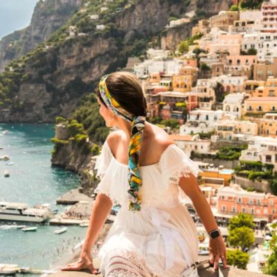 Mladá žena pred farebným mestom Positano v Taliansku.