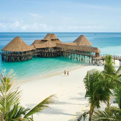 Krásna piesková pláž a drevené mólo s reštauráciou. Zanzibar