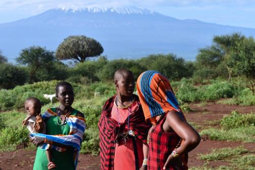 Tri masajské ženy s dieťatom a Kilimandžáro v pozadí.
