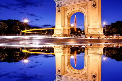 Víťazný oblúk v Bukurešti s odrazom po západe slnka.