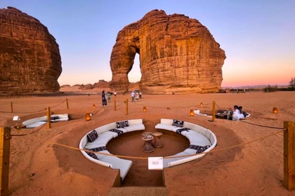 Slonia skala pri západe slnka a posedenie v piesku v AlUla v Saudskej Arábii.