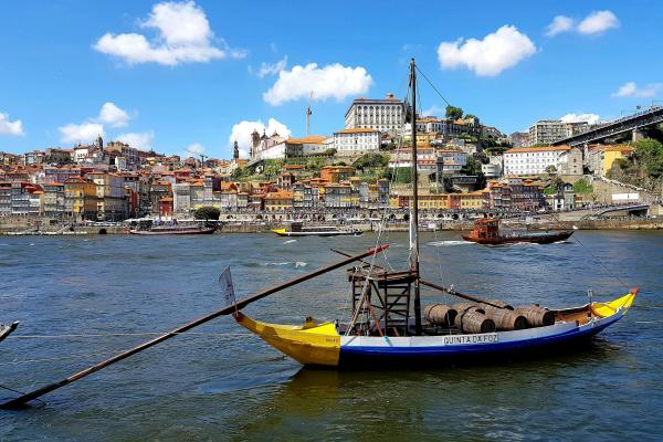 Loď so sudmi a mesto Porto v Portugalsku.