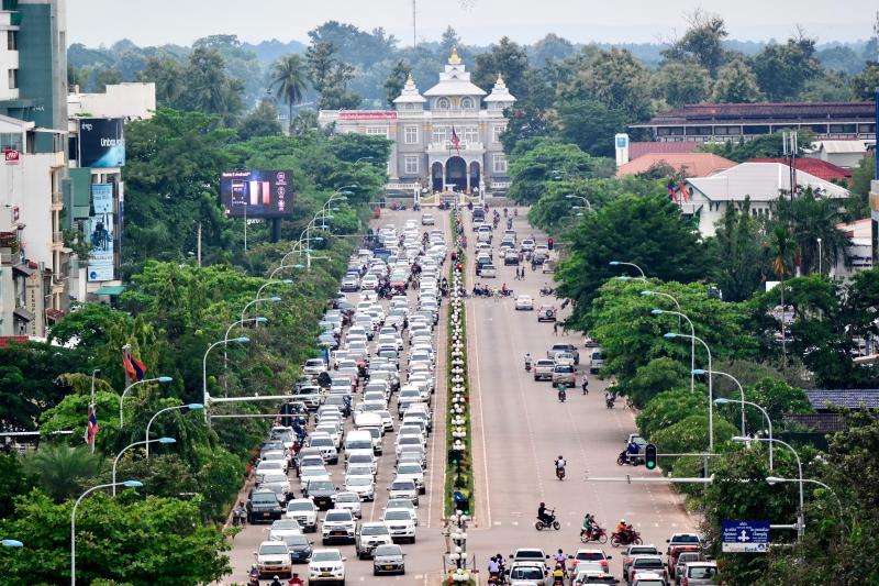 Hlavné mesto Laosu - Vientian, s hlavnou cestou, stromami a budovami. 