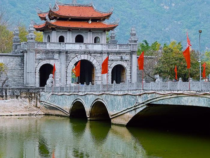 Histroická brána červená strecha, most a rieka. Vietnam. Foto: unsplash.com