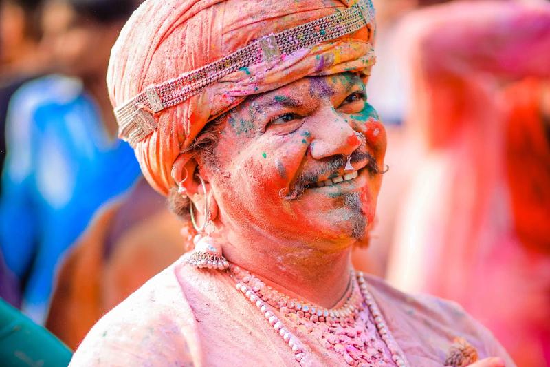 Muž s farebnou tvárou počas sviatku Holi v Indii.