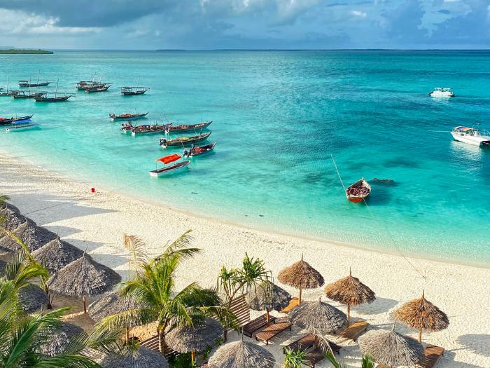 Lode na mori, palmy a slnečníky. Zanzibar.