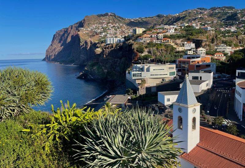 Skalné masívy, domy a kostol na Madeire.