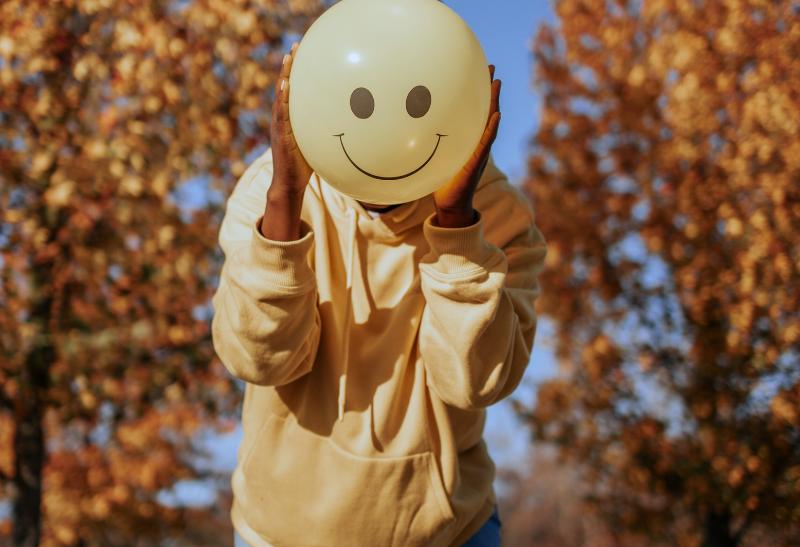 Žena v žltej bunde a so žltým balónom.