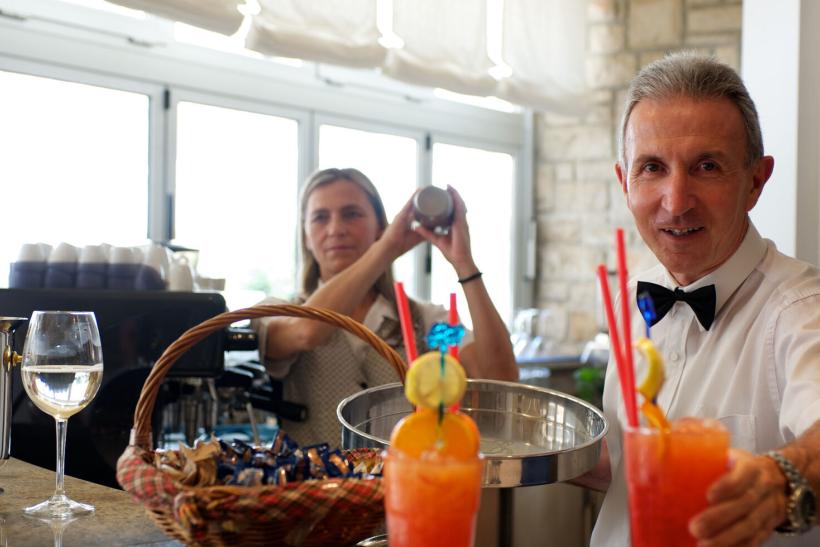 Barman a barmanka pri bare a robení nápojov.