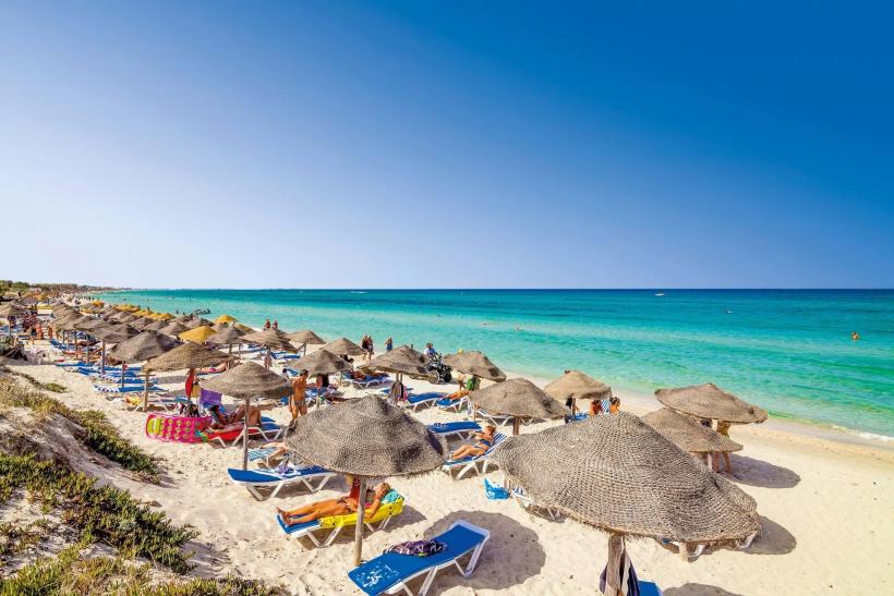 Piesková pláž, lehátka a ľudia v Mahdii