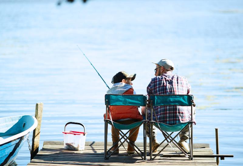 Chlapec a otec spolu na rybách pri jazere.