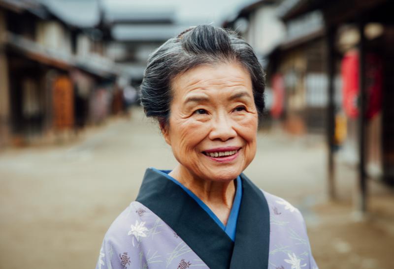 Usmiata japonská žena vo fialovom kimone.