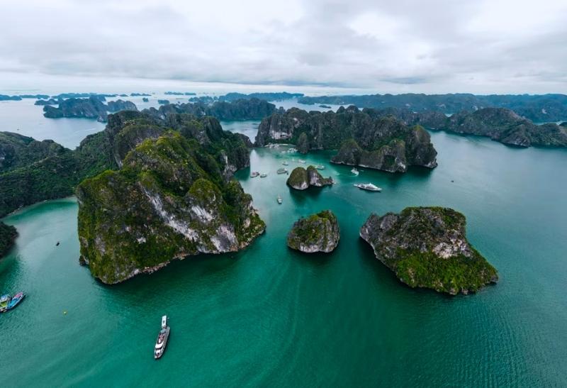 Zátoka Halong s vápencovými ostrovmi vo Vietname a loď.